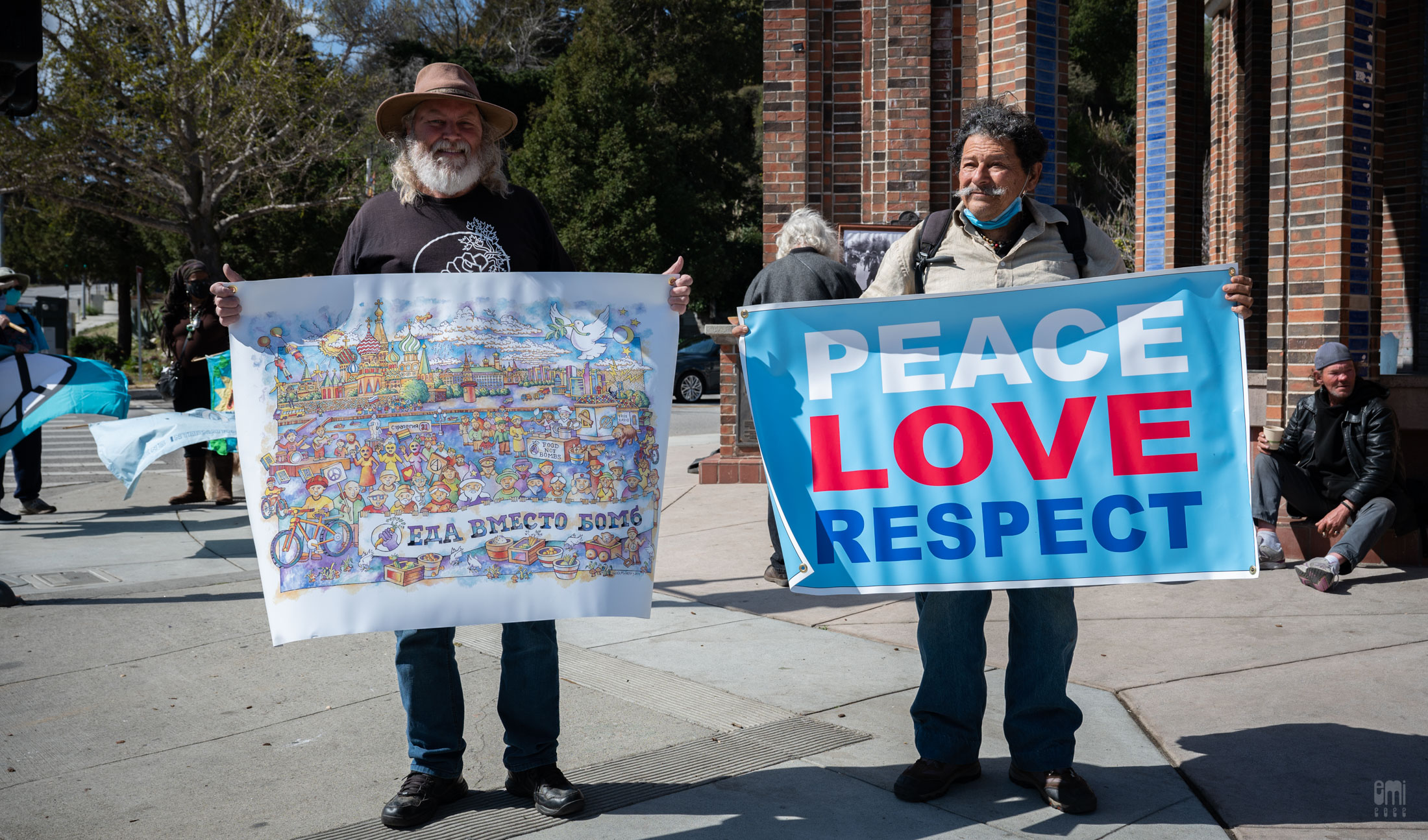 Organization leader Keith McHenry is getting ready for the protest with Russian version of Food Not Bombs banner, while serving food to those people in need at The Clock Tower, Santa Cruz , CA on Sunday afternoon March 6th , 2022 photo by emi